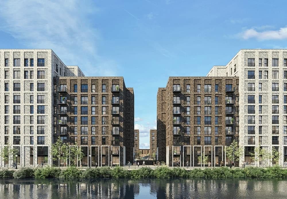 Developer's render of two brick apartment blocks beside a river, reflected in the water